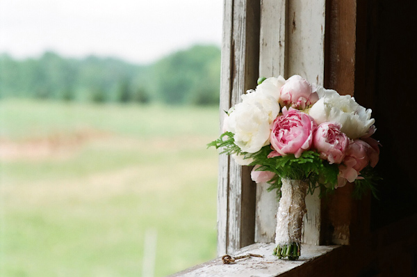 ivory and light pink bouquet leaning against a rustic wooden window frame-photo by North Carolina wedding photographer Richard Israel 